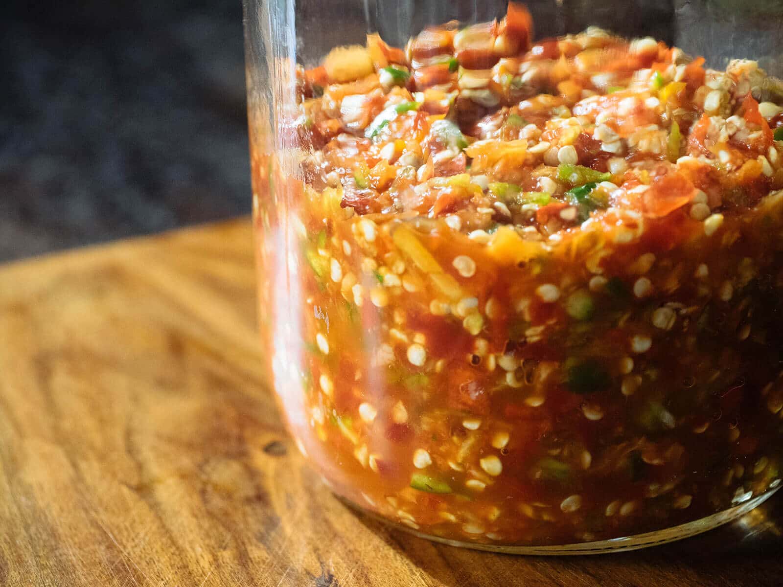 Jar of chile peppers fermenting on a counter