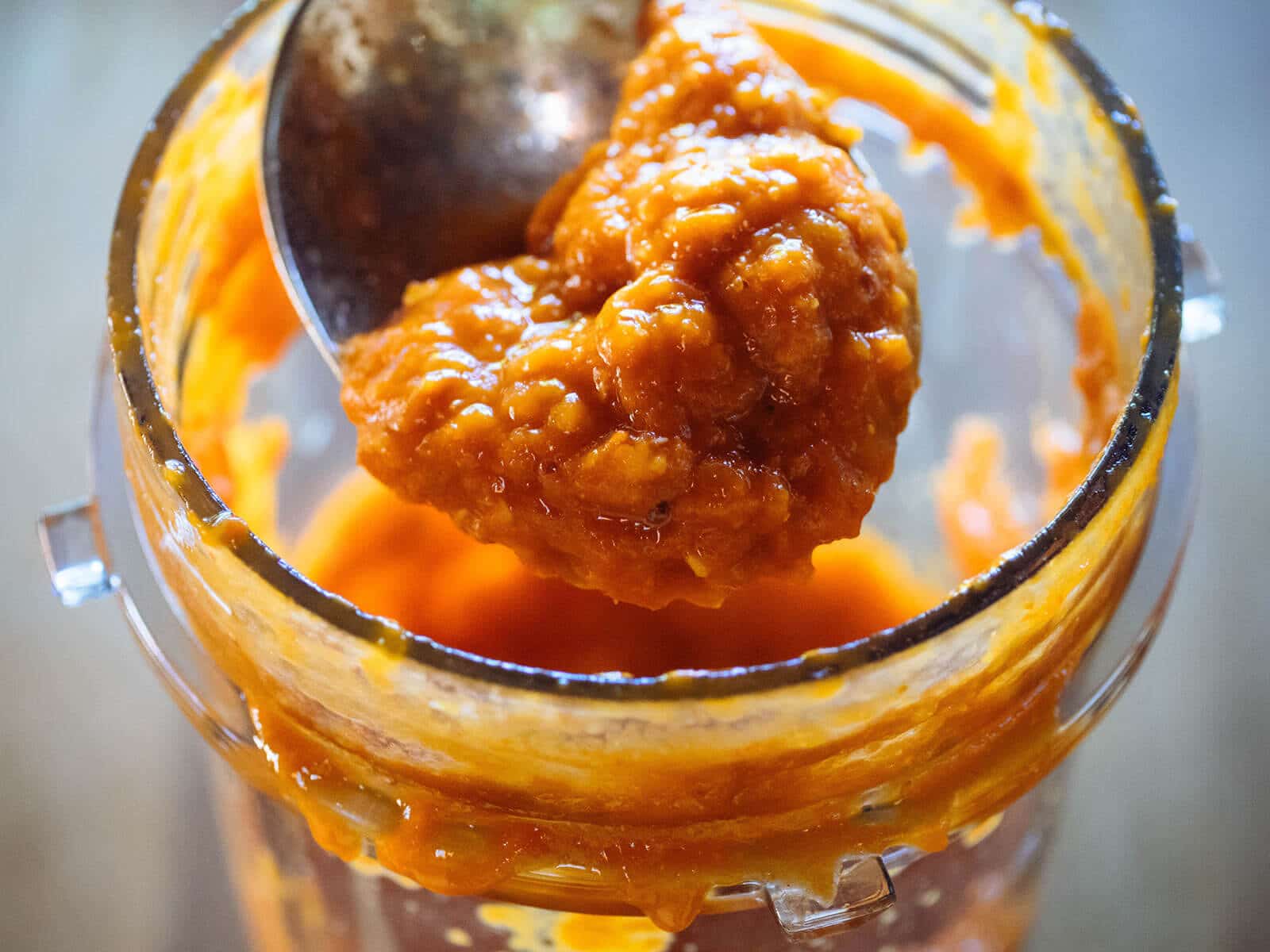 Spoon scooping up a portion of blended fermented chile peppers