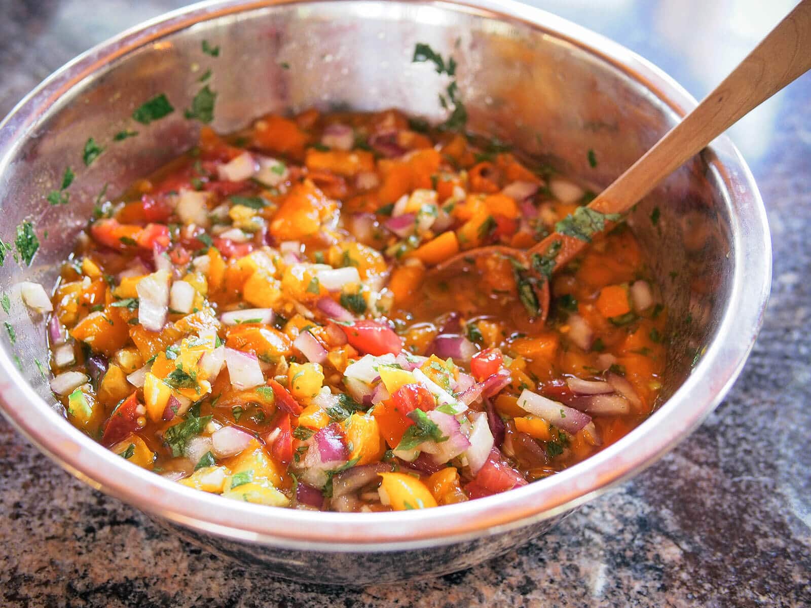 Bowl of fermented salsa mixed with a wooden spoon