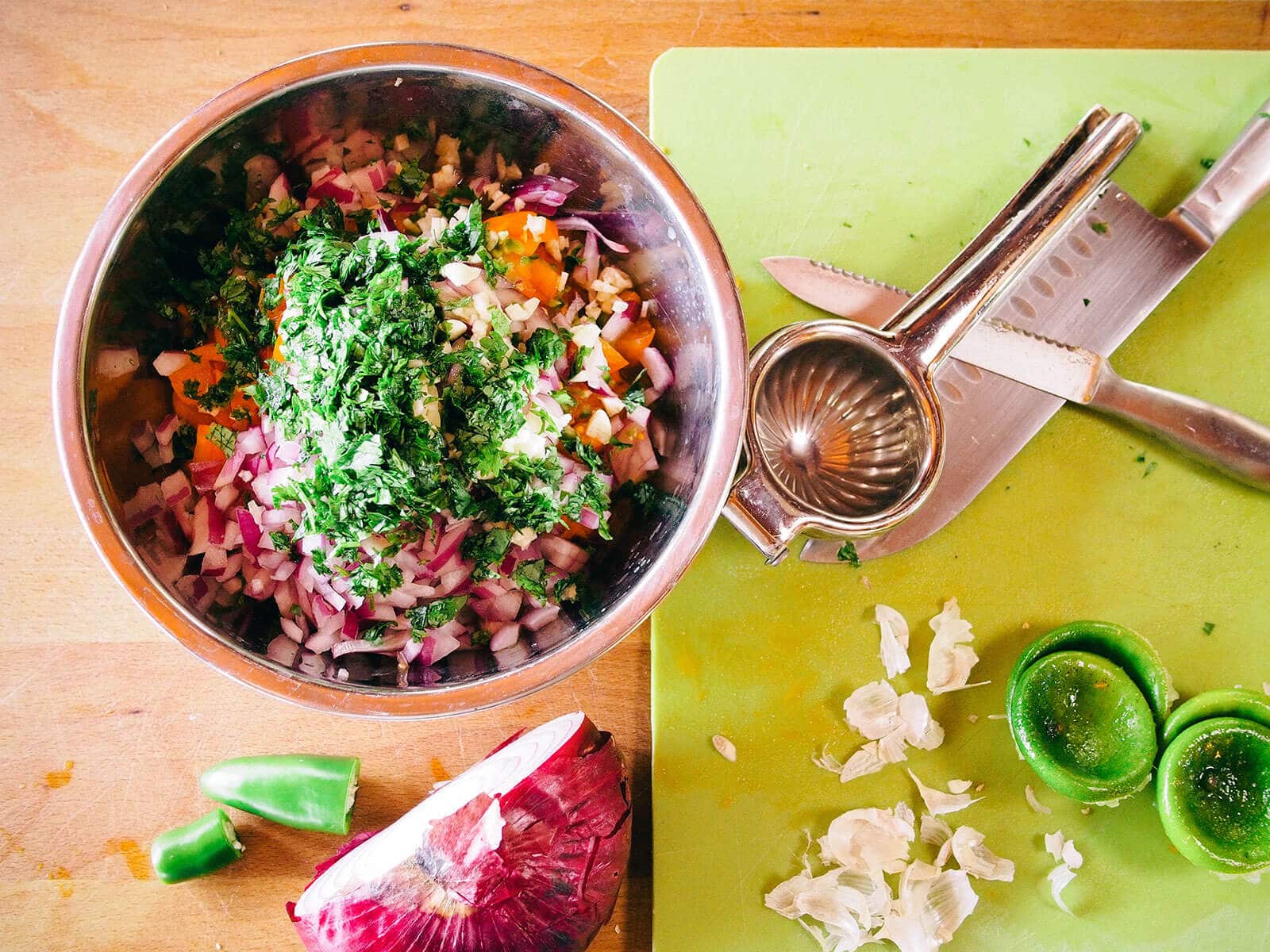 Salsa ingredients being prepped and diced on cutting boards