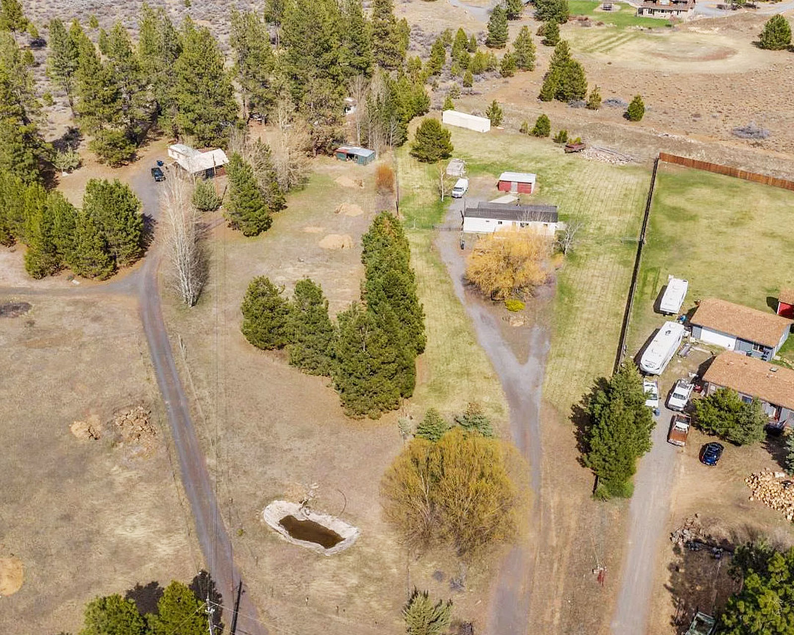 Aerial view of rural parcel with evergreen and deciduous trees