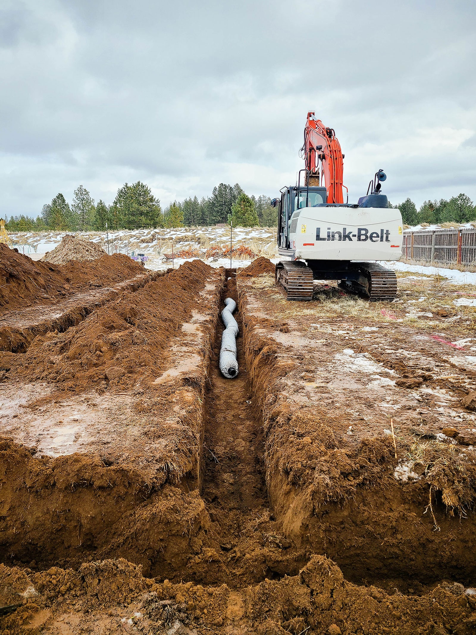 An excavator installing a septic system on a residential property